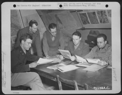 Thumbnail for General > Office Of The 379Th Bomb Group Study Aerial Photographs Of The Target Area As They Plan Another Raid On Enemy Installations.  England, 12 March 1945.