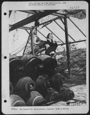 General > The Combination Of Heavy Explosives And Combat Airmen Spells Doom For The Nazis; Here, A Flyer Adjusts His Helmet As He Poses Near A Camouflaged Bomb Dump On The 91St Bomb Group Base At Bassingbourne, England.