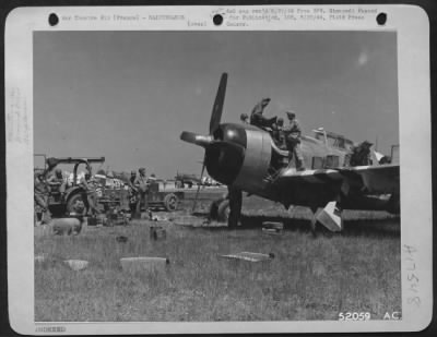 Thumbnail for Refueling > "Somewhere in France." At one of the 9th Air Forces emergency landing strips in France members of a crew are seen working on a P-47 Thunderbolt fighter.