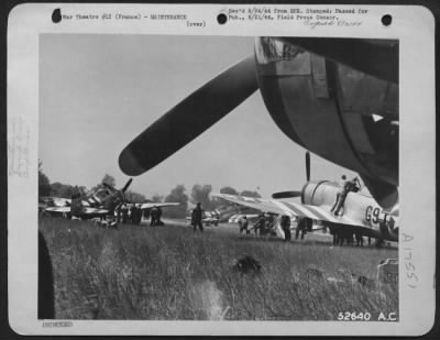 Thumbnail for Refueling > In this general view at one of the emergency landing strips crew members are shown going over the Republic P-47 Thunderbolt fighters of their squadron.