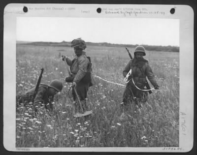 Mines > The fields of Northern France are being searched for "mines" and "Booby traps" left by the Germans and that is the job pictured in progress. Men of the 9th AF, "Sappers" work in advance of the on-coming Allied Forces to detect where these explosives