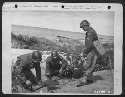 Mines > Sgt. Albert Kilpatrick of Kinston, N.C. (right, with mine detector) has located German mine, buried near a recently evacuated gun position in France. His two assistants begin the highly dangerous task of uncovering the live mine so that it may be