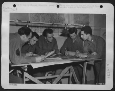 Thumbnail for General > This operation is called plotting at a 9th AF Recon Unit somewhere in France. Left to right are: S/Sgt Fred W. Schiesser, Chicago, Ill.; Sgt Raymond J. Roser, Woodhaven, N.Y.; Cpl Forest E. Wilson, Champaign, Ill.; Sgt Francis B. Foley, Chicago, Ill.