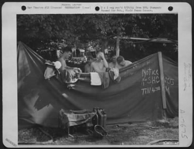 Thumbnail for General > FRONT LINE BATH TUB WITH SHOWERS . . . While some prefer tea, these 9th AF, Fighter-Bomber pilots freshen up with a communal shower rigged up for their benefit at a point near their camp just behind the front lines in France. Note schedule