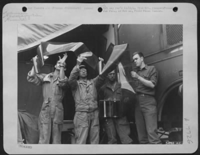 Thumbnail for Operations & Mapping > Technicians at a photographic reconnaissance unit with the 9th AF in France examine a roll of aerial film made by a photo reconnaissance plane. Left to right are: Sgt Lonnie W. Cameron, Denver, Colo.; Cpl Carl Knox, Syracuse, N.Y.; Sgt Robert S.