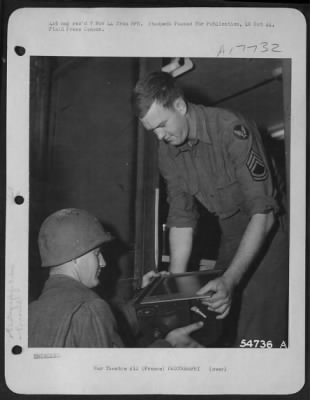 Processing > FRANCE-Film taken from a plane just returned from a Photo Reconnaissance Mission, turned in at the field lab for processing. Left to right at this Ninth Air Force base are: S/Sgt Bert Reiser of Lakeland, Fla.; and Lab Chief T/Sgt Robert W. Anderson