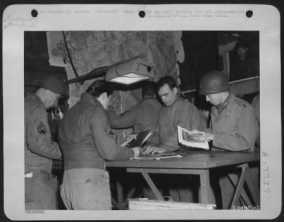 Thumbnail for Processing > Looking over some finished prints in a photo lab of a Photo Recon Unit somewhere in France are (left to right) S/Sgt Paul Ftak, Jr., of Chicago, Ill.; S/Sgt John Kachuba of Long Island City, N.Y.; T/Sgt Russel L. Herbruck of Cleveland, Ohio; Cpl