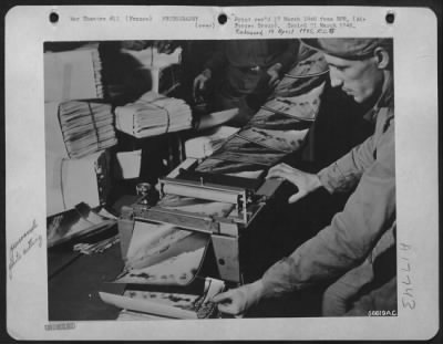 Thumbnail for Processing > FRANCE--The guillotine cuts the continuous chain into individual prints which are stacked and bundled for the needs of the various users, and ready for the jeep run to the boys at the front. S/Sgt. Edward Miazga of Erie, Pa., counts and checks