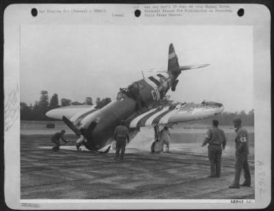 General > Ground crewmen extinguish a fire started under the P-47 that crashlanded, while others remove the hood, to take out the unconscious pilot.