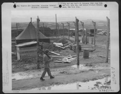 Thumbnail for Consolidated > A guard walks his post around the stockade at an 11th Air Force base in Amchitca, Aleutian Islands. 12 October 1943.