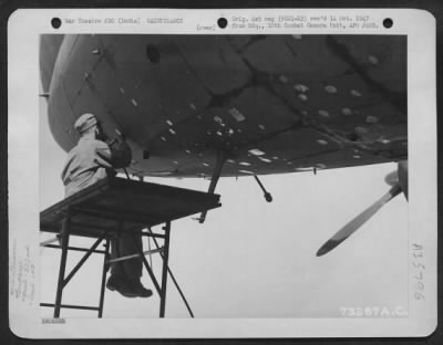 Consolidated > Sgt. Albert Osborne Of The 382Nd Air Service Group'S Sheet Metal Shop Patches The Flak Holes On The Nose Of A Curtiss C-46 Of The 4Th Combat Cargo Group At Chittagong, India.  11 March 1945.