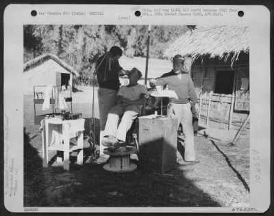 Thumbnail for Consolidated > At Hailakandi, India, The Dental Officer Maintained An Outdoor Clinic, Using A Grass Awning For A Sunshade.  Here, He Gives Dental Treatment To One Of The Men Of The 1St Air Commando Force.