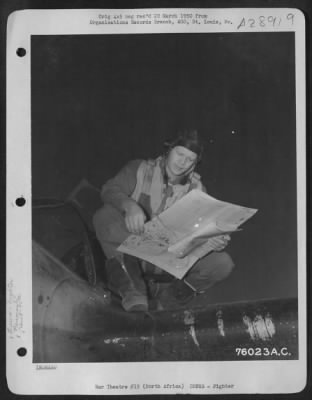 Thumbnail for Consolidated > Lt. Bloomquist, pilot of the 90th Photographic Reconnaissance Wing, studies a map before taking off on a mission from an air base somewhere in North Africa.