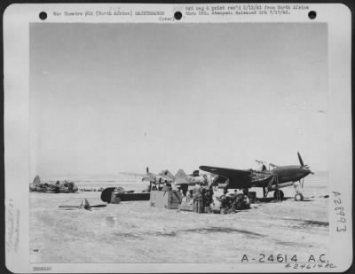 Thumbnail for Consolidated > With Maj. Gen. Doolittle's Strategic Air Force, North Africa-Lockheed P-38 in foreground being repaired from salvage parts of the other two planes in the background.