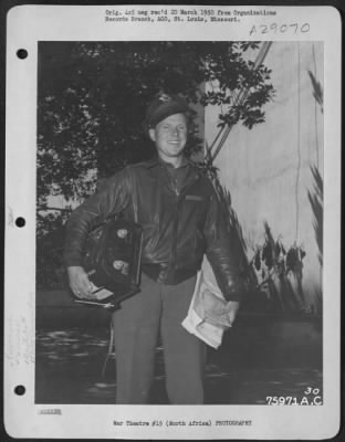 Thumbnail for Consolidated > Smiling happily after his return from a mission, 2nd Lt. John R. Hoover, Cresson, Pa., of the 90th Photographic Reconnaissance Wing, heads for the photo laboratory with the camera magazine under one arm and his maps and escape kit under the other.