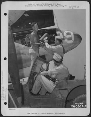 Consolidated > Personnel of the 90th Photographic Reconnaissance Wing unload camer magazines from the nose of a plane at an air base somewhere in North Africa.