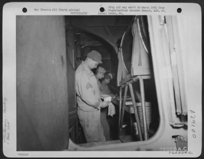 Thumbnail for Consolidated > An Air Force Sergeant develops prints in a French Potez-54 "Flying Laboratory" at a 90th Photographic Reconnaissance base somewhere in North Africa.