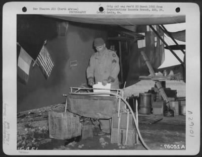 Thumbnail for Consolidated > An American G.I. washes prints beside a French Potez-54 "Flying Laboratory" at an air base somewhere in North Africa. 90th Photographic Reconnaissance Wing.