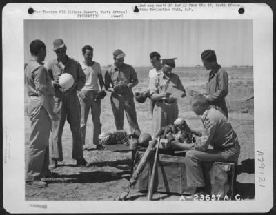 Consolidated > Plenty of athletic equipment is needed by the men of the U.S. 9th Air Force stationed in the Libyan Desert. They get it from American Red Cross Field Director Ray L. Goodridge, of 210 Lark Street, Rochester, New York, shown here distributing the