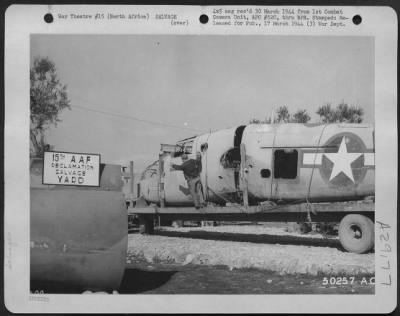 Thumbnail for Consolidated > North Africa-Veteran of 21 missions, "Sheepherder" is hauled in to the Reclamation and Salvage Yard aboard mobile float to be dismantled and valuable parts reclaimed for reissue.