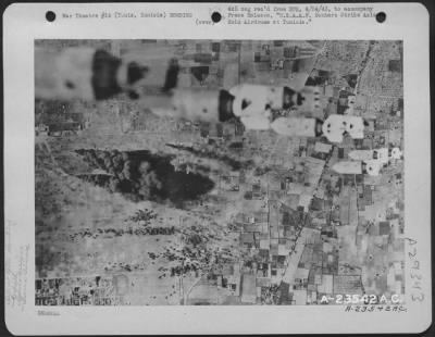 Thumbnail for Consolidated > Tunis, Tunisia-American Air Forces bombs rained down on enemy aircraft, some of which were trying to take off from El Aouina Airdrome at Tunis. Shown are bombs dropping on the airfield, while below smoke rises from bombs that have just landed