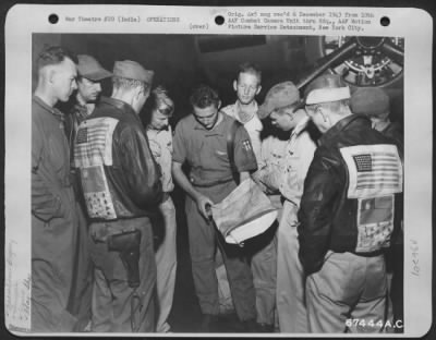 Consolidated > At An Air Base In India, Pilots And Crew Members Pay Strict Attention As A Pilot Explains The Choice Of Flight Line To Avoid Enemy Interception During A Raid Over A Japanese Supply Base At Kamaing, Burma, In 1943.