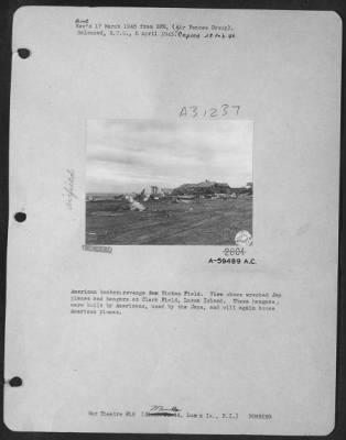 Thumbnail for Consolidated > American bombers revenge for Hickam Field. View shows wrecked Jap planes and hangars at Clark Field, Luzon Island. These hangars were built by Americans, used by the Japs, and will again house American planes.