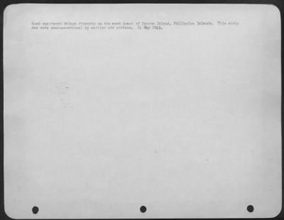 Consolidated > Bomb spattered Malago Airstrip on the west coast of Negros Island, Philippine Islands. This strip was made non-operational by earlier air strikes. 14 May 1945.