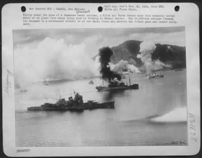 Thumbnail for Consolidated > Flying under the guns of a Japanese heavy cruiser, a Fifth Air Force bomber made this dramatic aerial photo of at least four enemy ships sunk of burning in Rabaul Harbor. The 10,000-ton cruiser (bombed and damaged in a subsequent attack) is of the