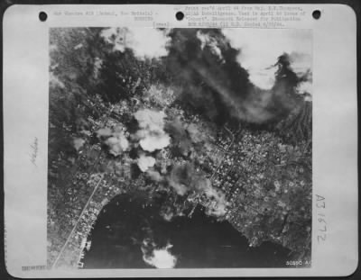 Thumbnail for Consolidated > Town of Rabaul, New Britain is bombed on 2 March 44 by all-star cast of 48 SHDs, 24 TBFs, 16 P-40s and 24 B-25s, dropping 1,000 lb bombs on Customs Wharf.