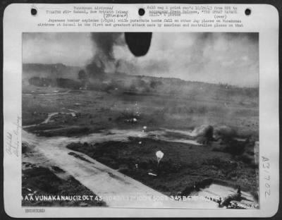 Consolidated > Japanese bomber explodes (right) while parachute bombs fall on other Jap planes on Vunakanau airdrome at Rabaul in the first and greatest attack made by American and Australian planes on that