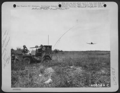 Thumbnail for Consolidated > In close air-ground cooperation, it is necessary to have a radio jeep near the target to contact the planes and direct them to the vital spot. In this photo, a SBD light bomber is buzzing the JASCO jeep while ground personnel talks with the pilot