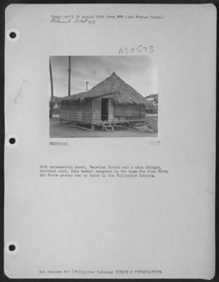 Thumbnail for Consolidated > With screened-in porch, Venetian blinds and a nipa shingle, thatched roof, this bamboo bungalow is the home for four Fifth Air Force ground men on Luzon in the Philippine Islands.