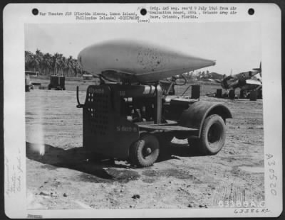 Thumbnail for Consolidated > The problem of providing airplanes with belly tanks for long range missions has been adequately solved by using a standard tug with a frame, which holds the belly tanks in position. Florida Blanca, Luzon Island, August 1945. Luzon, Philippine Islands