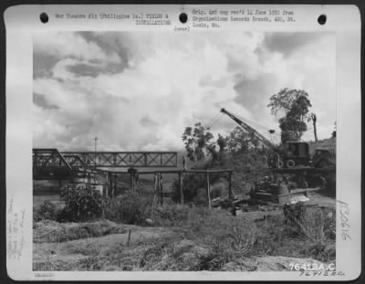 Consolidated > Members of the 1876th Eng. Aviation Battalion repair a bomb damaged bridge over Magat River on Luzon Island, Philippines, 26 June 1945.