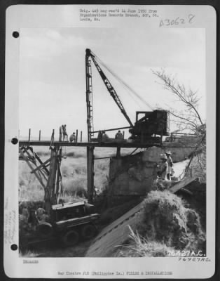 Consolidated > Members of the 1876th Eng. Aviation Battalion repair a bomb damaged bridge somewhere in the Philippine Islands.