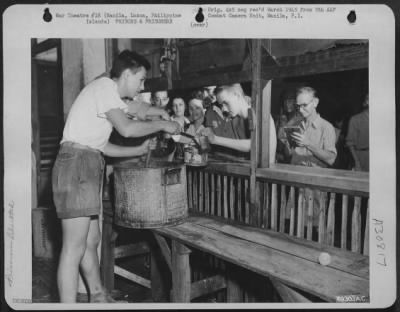 Thumbnail for Consolidated > In the dreary basement of the Santo Tomas Prison, G.I.'s dole out food to the hungary internees. February 1945. Manila, Luzon, Philippine Islands.