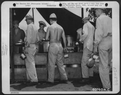 Consolidated > G.I.'s line up for chow at a field kitchen in Manila, Philippine Islands. May 1945.