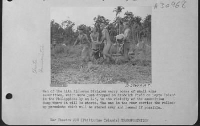 Thumbnail for Consolidated > Men of the 11th Airborne Division carry boxes of small arms ammunition, which were just dropped on Randolph Field on Leyte Island in the Philippines by an L-5, to the vicinity of the ammunition dump where it will be stored. The man in the rear