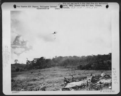 Consolidated > Flying at tree-top level, this Douglas C-47 "Skytrain" drops rations to front line troops of the 185th Infantry Division in the hills of Negros Island. No road has yet been built leading to the position of the fighting. Negros, Philippine Islands.