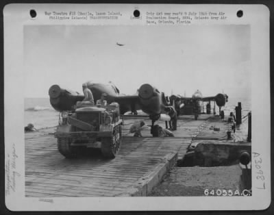 Thumbnail for Consolidated > Neilson Field 5th Air Service Area Command Depot #7-Manila, Luzon, Island, Philippine Islands, 8 May 1945. Lockheed P-38 "Lightnings" are shown being brought ashore on barges four at a time, and towed off the barge by a tractor.