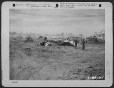 Thumbnail for Consolidated > This Lockheed P-38 crashed on landing at Lingayen Airstrip, Luzon Island, Philippine Islands. Though the plane was completely washed out, the pilot was uninjured. Mechanic standing in the cockpit is salvaging instruments and other undamaged acessory