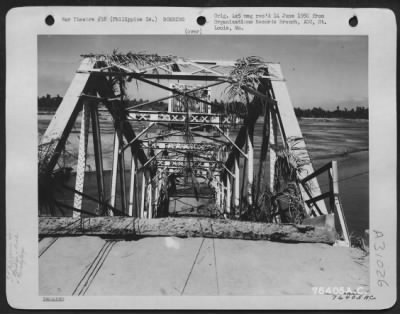 Consolidated > Bomb damaged bridge somewhere in the Philippine Islands. Note the attempt the Japanese made in camouflaging the bridge with foliage.