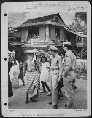 Consolidated > The Knack Of Carrying Bundles On The Head Is Picked Up By Filipinos At An Early Age.  Residents And Fiesta Guests Who Are Celebrating The Liberation By 11Th Airborne And 1St Cavalry Divisions Of The U.S. Army, And The Feast Day Of Santa Martha, Patron Sai