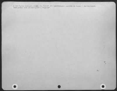 Consolidated > A Low Flying Transport Drops Its 'Stick' Of 8 Paratroops Squarely On Target On The Shattered, Bomb Pocket Ruin Of Corregidors Topside.