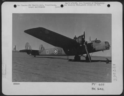 Thumbnail for Consolidated > A transport aircraft on the airfield at Marble Arch, Tripolitania, Libya. The famous arch can be seen behind its tail in the background.