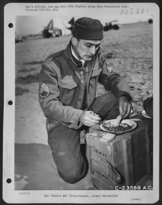 Thumbnail for Consolidated > Using a box for a table, S/Sgt. Baker took time out for lunch when the 57th Fighter Group in Tripolitania, Libya moved into a new airbase near Tripoli.