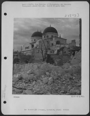 Consolidated > All around Bengasi Cathedral there is widespread damage done by R.A.F. bombs during attacks on the harbor. But the building itself is not seriouslyt damaged. Scars from flying masonry and bomb splinters are the only marks left on its walls by Allied