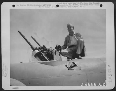 Thumbnail for Consolidated > With Maj. Gen. Doolittle's Mitchell Bombers -S/Sgt. Billy Dykes, Meridian, Miss., upper-turret gunner on a B-25, looking over Gerbini airfield, Sicily. Below Billy is the rent in the fuselage where the flak entered. He received only minor face and