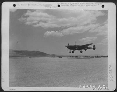 Consolidated > NORTH AFRICA-Wheels down, a Lockheed P-38 "Lightning" is caught landing after just-another-mission against the Axis in Sicily. This fighter air base was one of dozens which dotted the fertile valleys of North Africa.